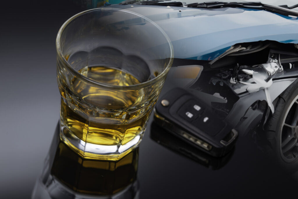 A glass of alcohol, a car key and a crashed car. Do not drink and drive.